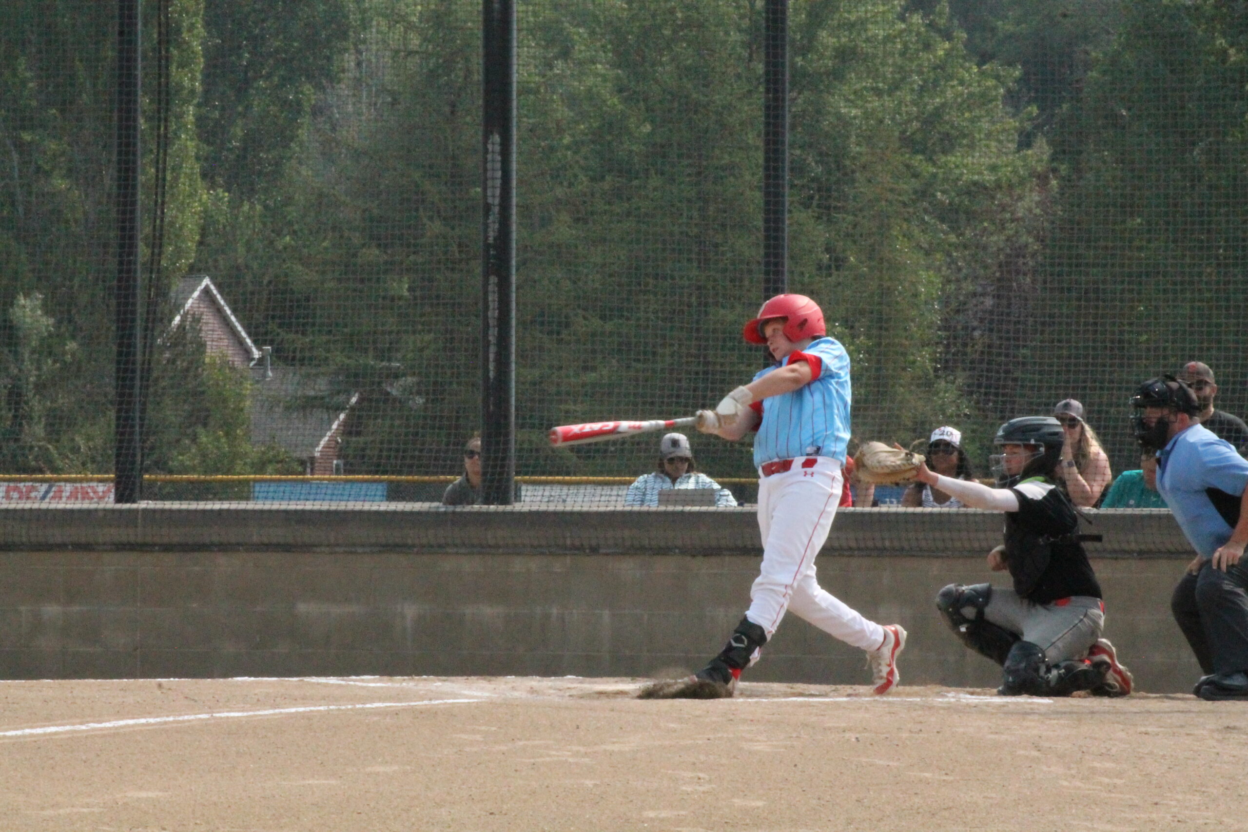 Youth baseball player swing at live pitch